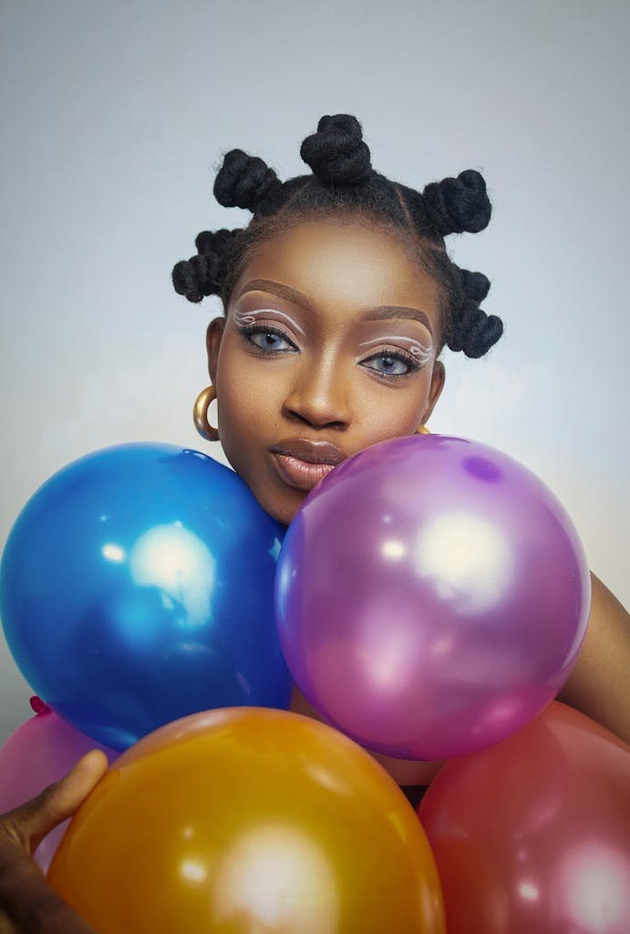 A striking portrait of a woman with bold makeup and colorful balloons.