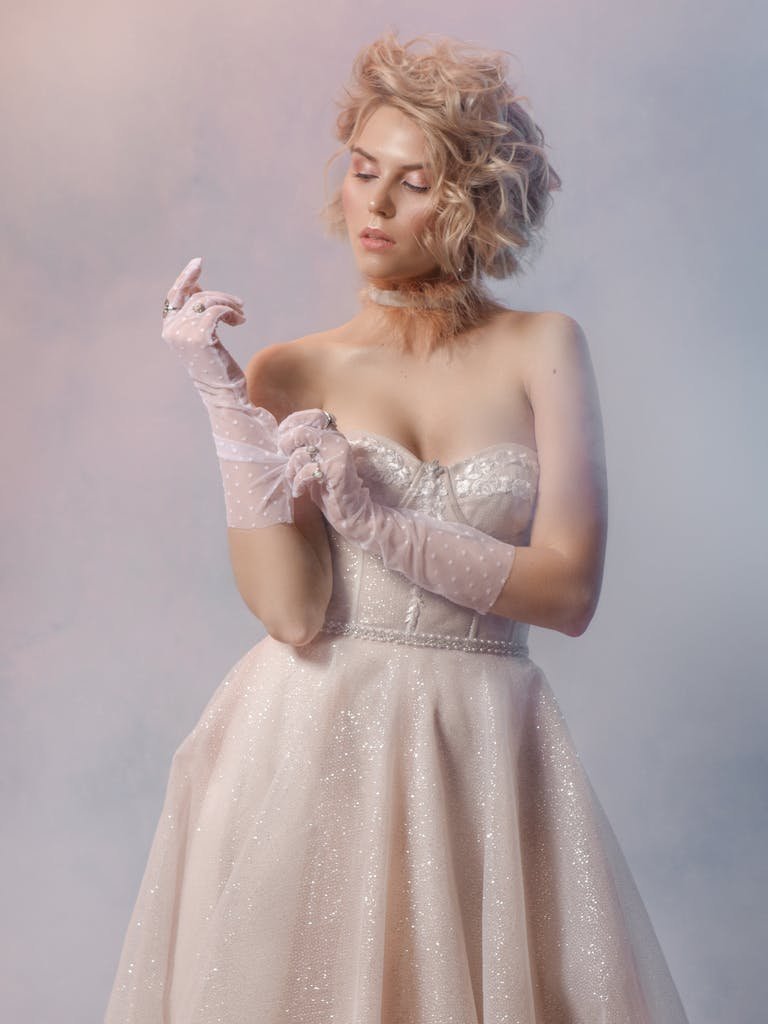 A stylish bride poses in an elegant gown with lace gloves. Perfect for wedding themes.