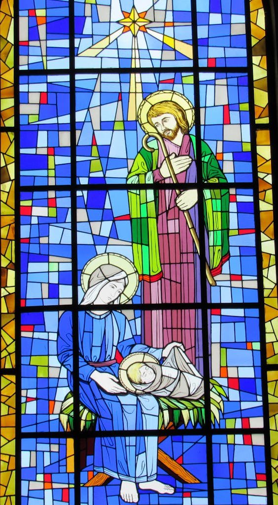 Colorful stained glass window depicting the Holy Family Nativity scene