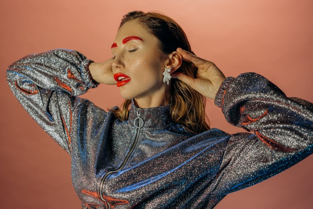 Stylish woman in a glittering outfit with bold makeup, exuding glamour and elegance.